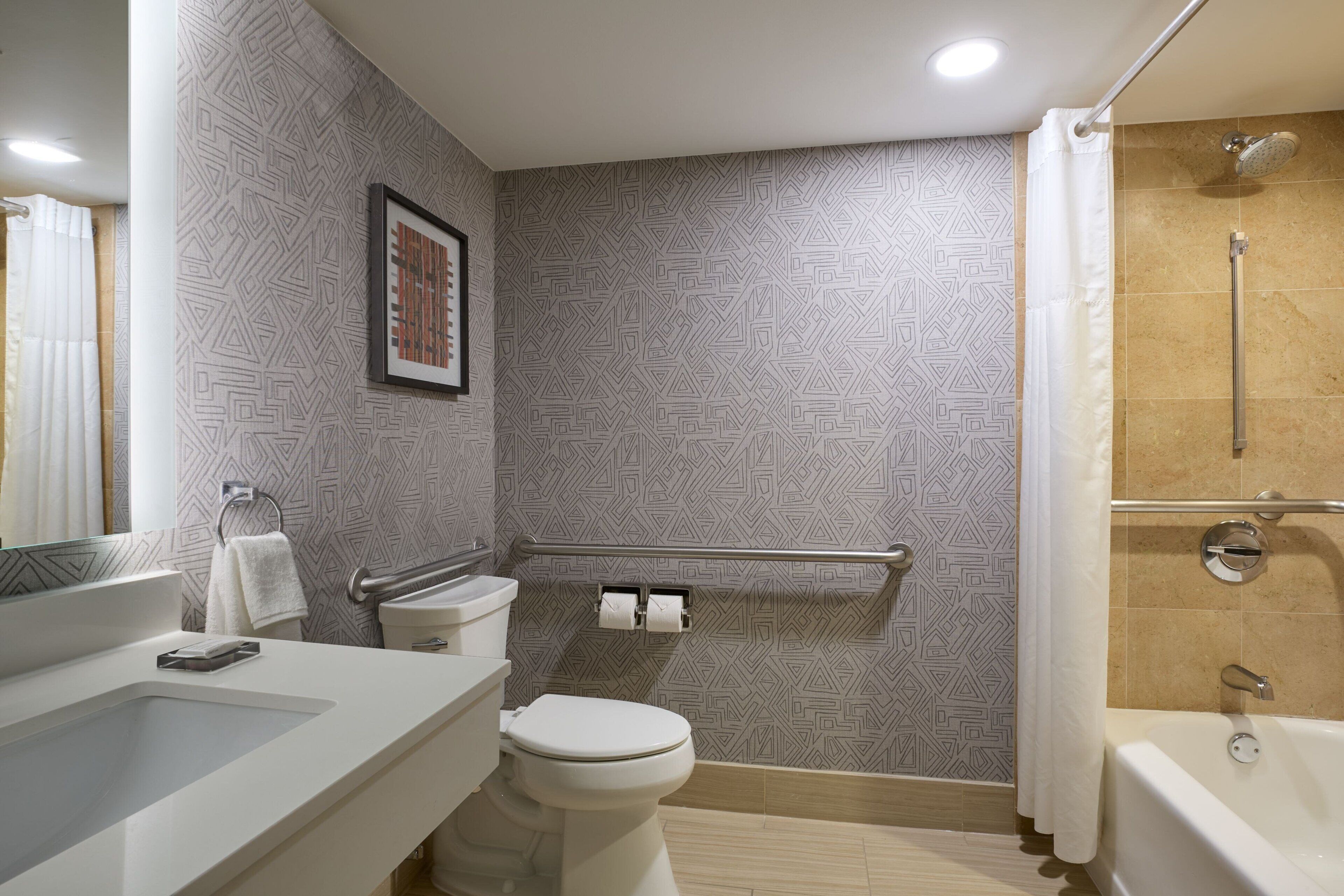 A modern bathroom with a shower, toilet, and sink.
