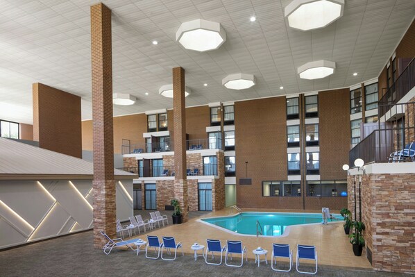 Ein Poolbereich im Innenbereich mit mehreren Ebenen, Liegestühlen, einem Pool und einer Treppe.