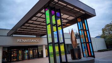 A modern building with a 'RENAISSANCE' sign, featuring a unique glass facade and a central sculpture.