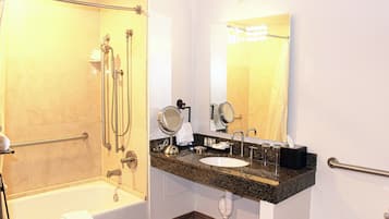 A modern bathroom with a walk-in shower, a sink with a vanity, and a large mirror.