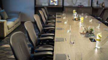 A conference room with a long table, chairs, and a sofa.