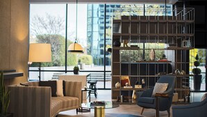 Ein modernes Wohnzimmer mit einer Couch, Sesseln, einem Couchtisch und einem Bücherregal.