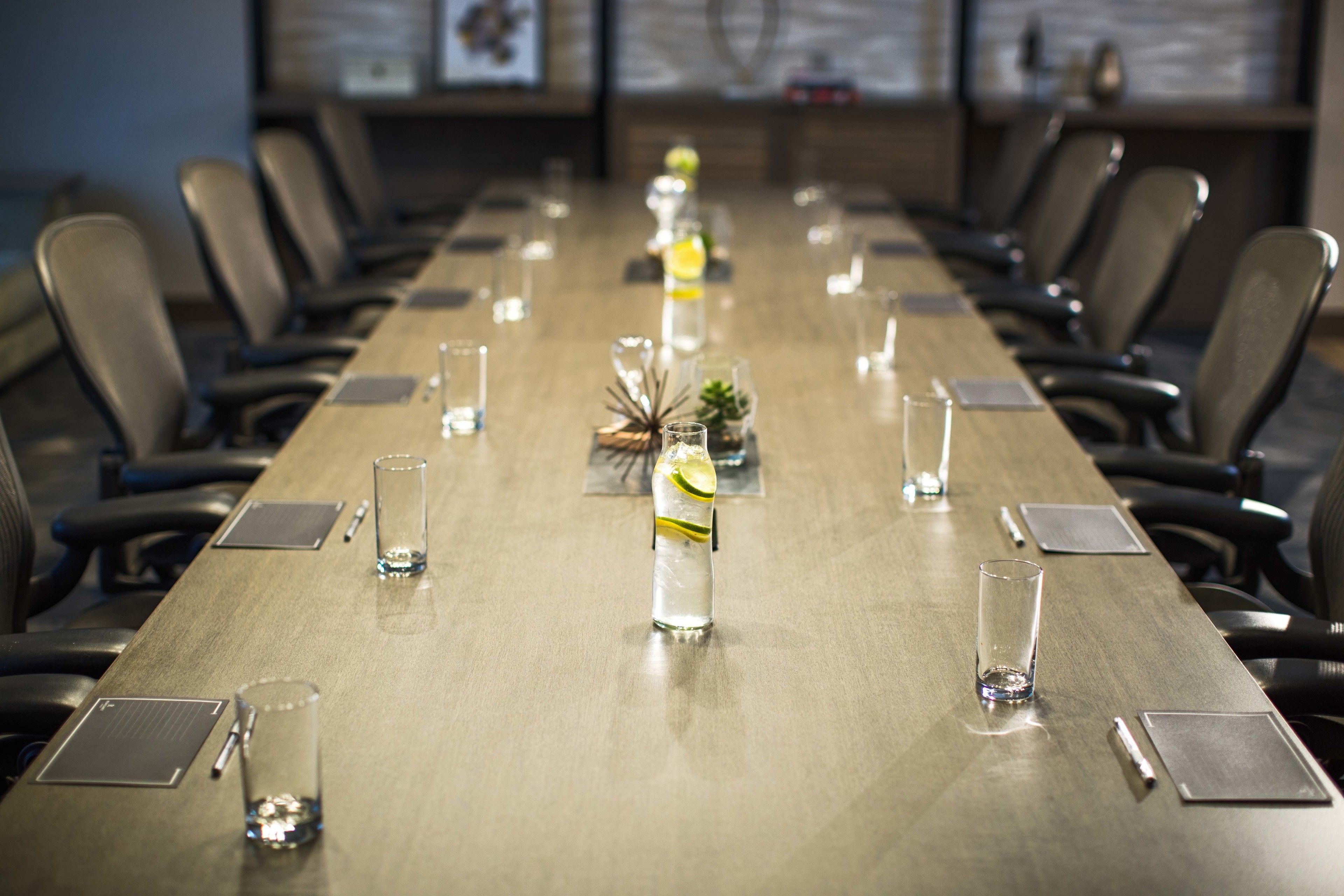 A conference room with a long table, chairs, and water bottles.