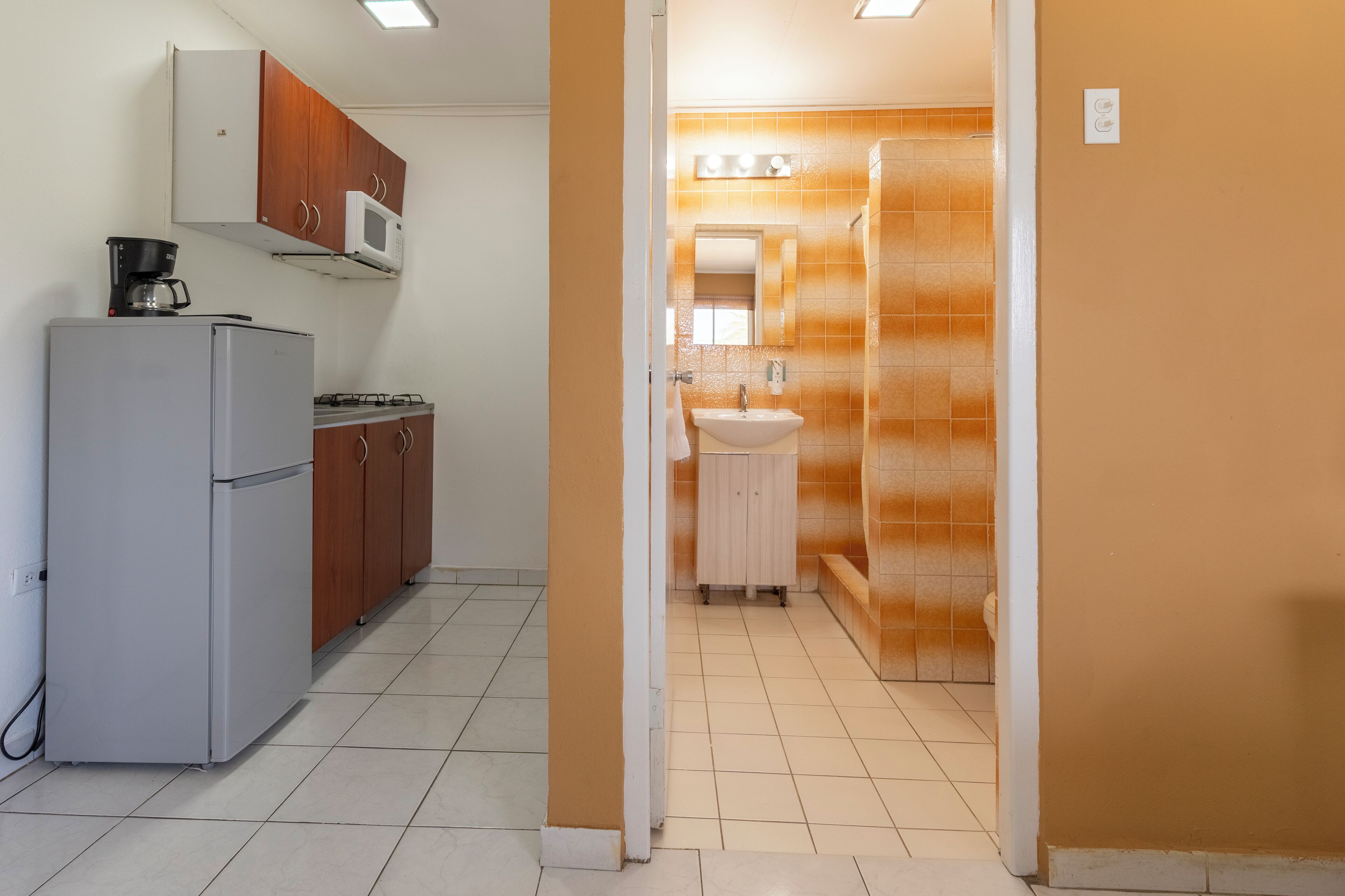 A kitchen with a refrigerator, microwave, and stove.
