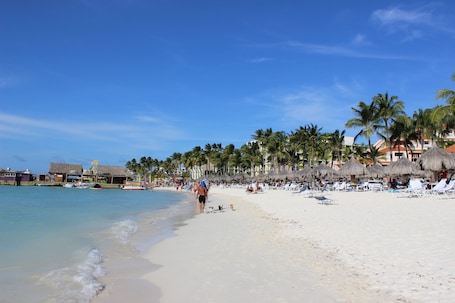 Una playa cerca, arena blanca, camas de playa