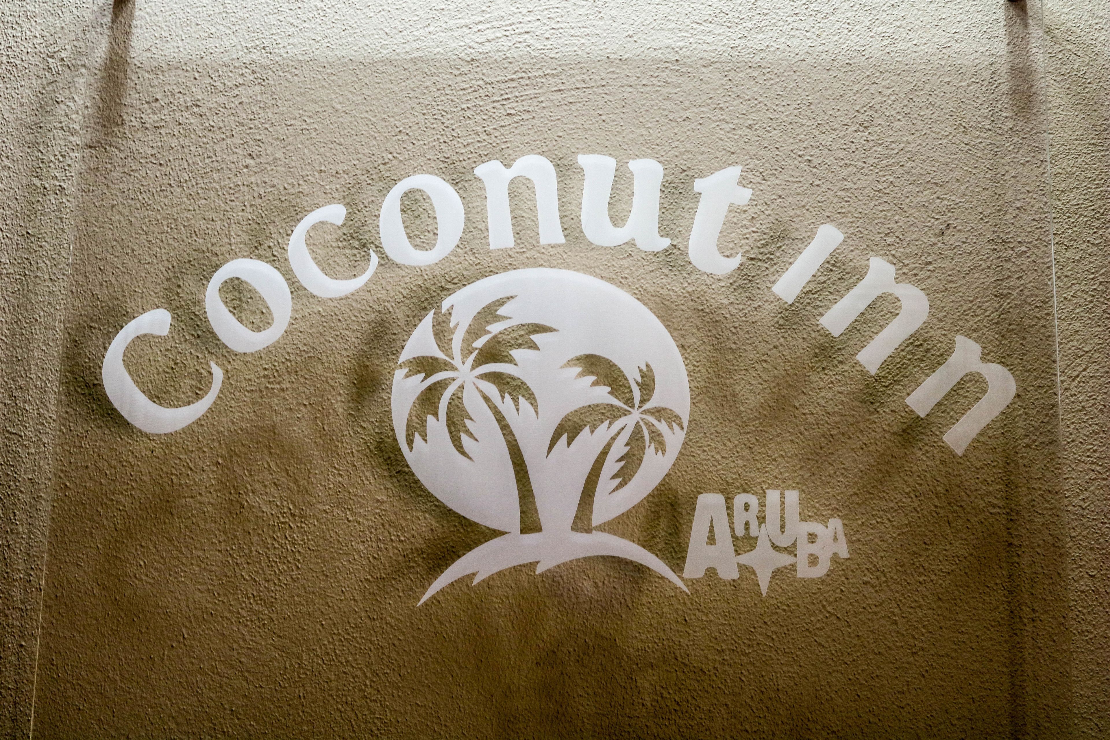 A towel with the text "coconut inn" and a palm tree logo.