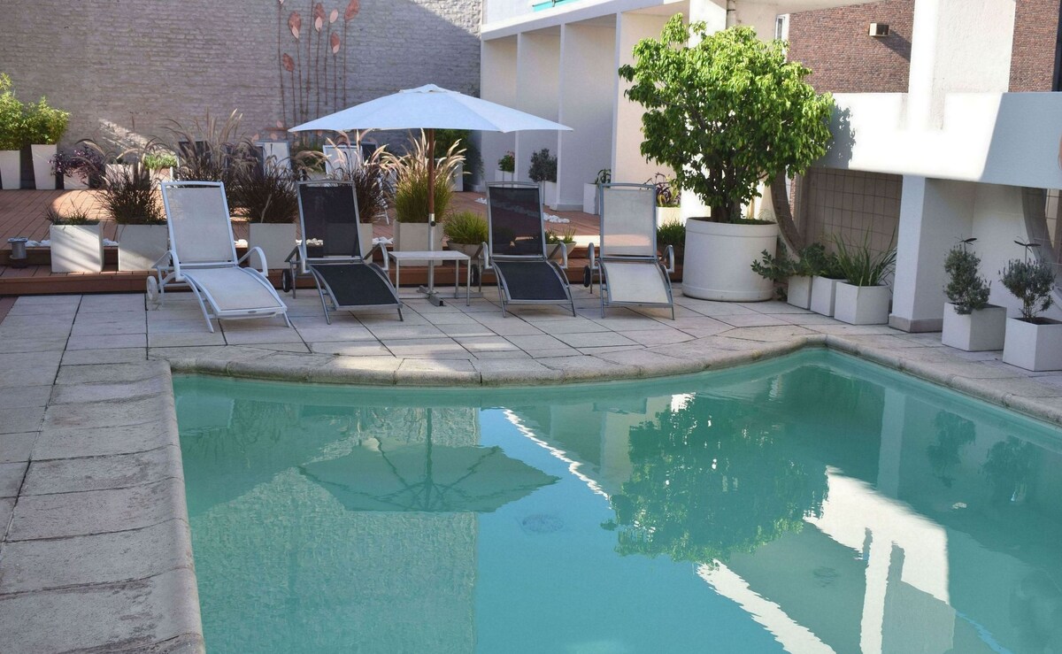 Una piscina al aire libre de temporada, tumbonas