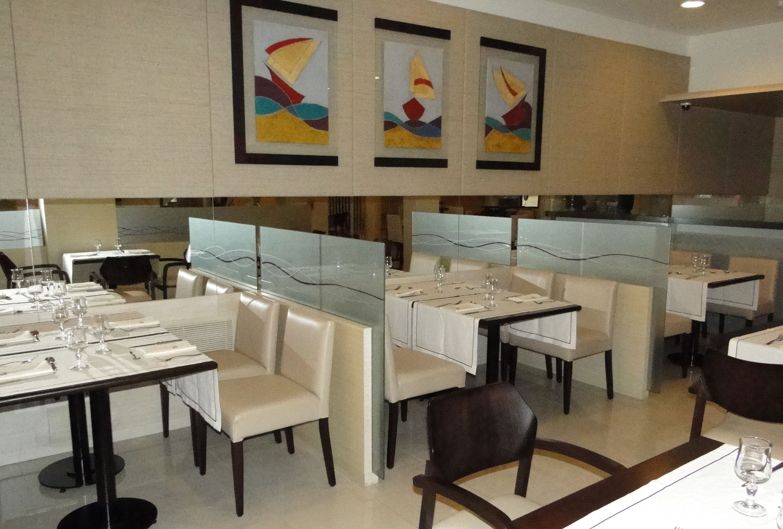 A restaurant with high tables and booths, framed artwork on the walls, and a clean, modern design.