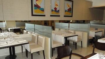 A restaurant with high tables and booths, framed artwork on the walls, and a clean, modern design.