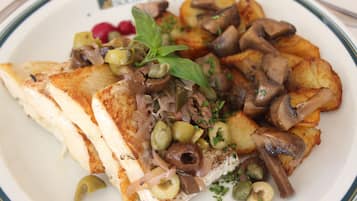 A plate of food with grilled chicken, mushrooms, and potatoes.