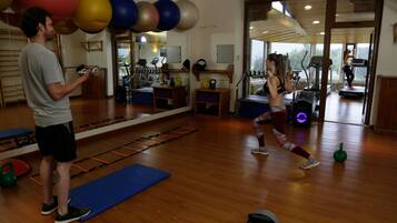 Un gimnasio con equipo de ejercicio, un espejo y suelo de madera.