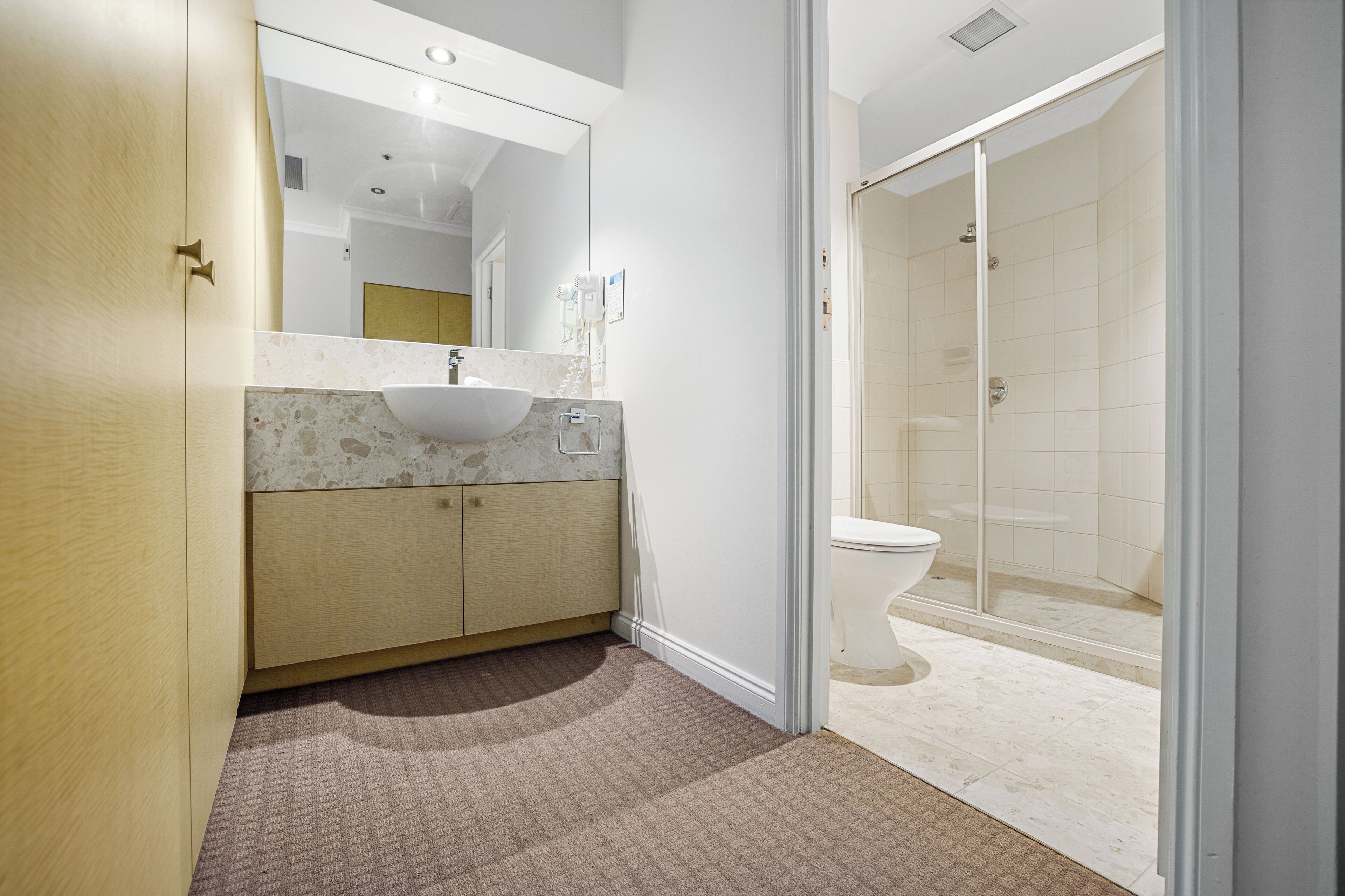 Une salle de bain moderne avec un lavabo, un miroir et des toilettes.