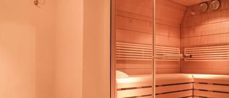 A sauna room with a bench and benches, glass walls, and a wooden ceiling.