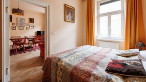 A room with a bed, a desk, and a chair. There is a window with curtains and a painting on the wall. - Altwienerhof Boutique Hotel (Vienna)