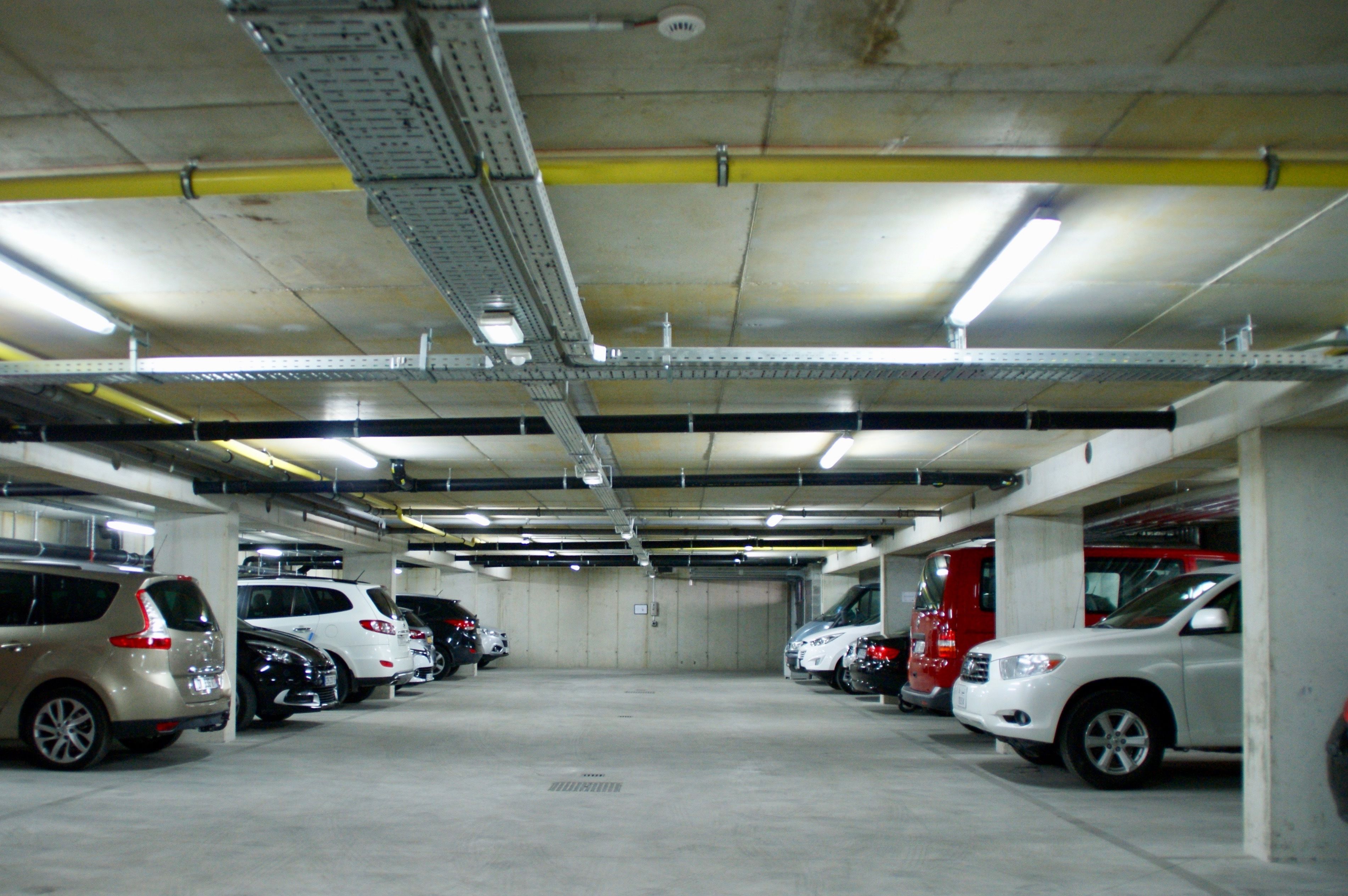 Un parking à plusieurs niveaux où plusieurs voitures sont garées à différents étages.