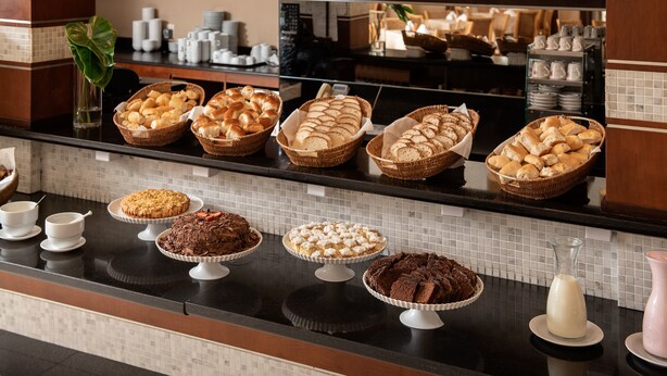 A breakfast buffet with various breads, pastries, and desserts. - Intercity Florianópolis (Florianópolis)