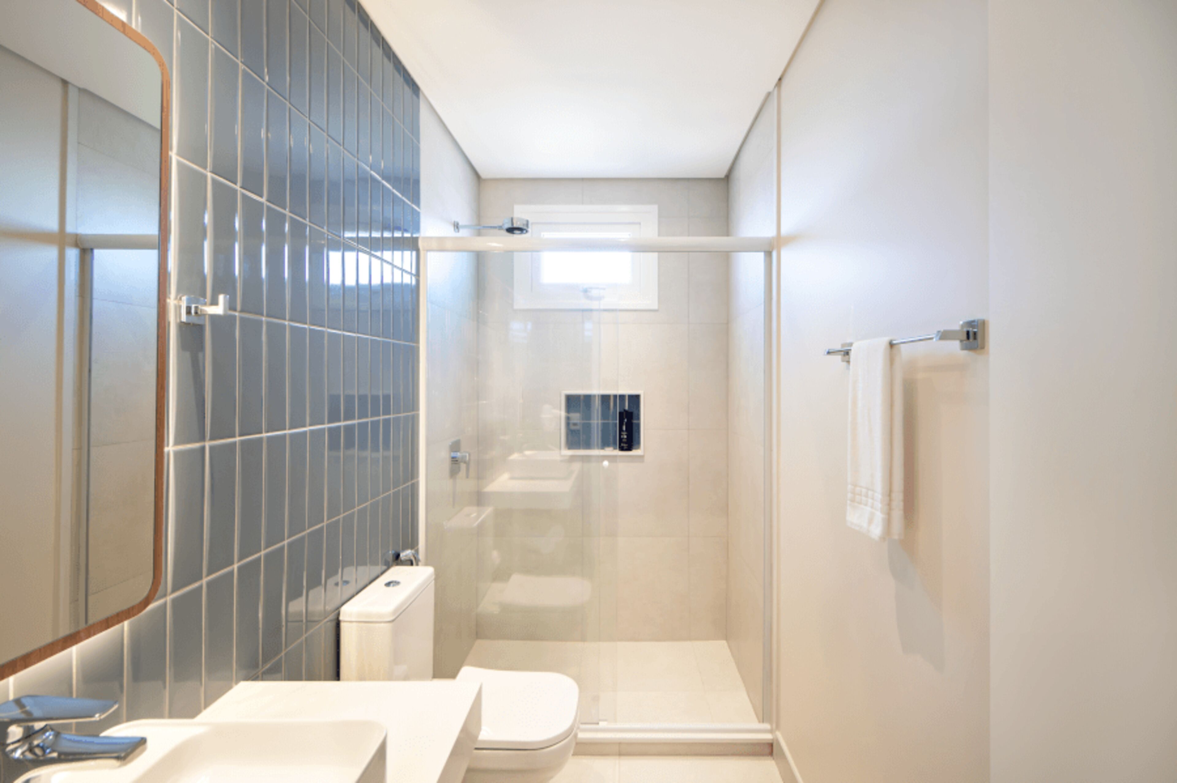 Ein modernes Badezimmer mit Duschkabine aus Glas, Toilette und Waschbecken.
