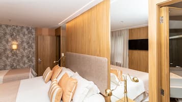 A hotel room with a large bed, a bedside table with a lamp, and a mirror.