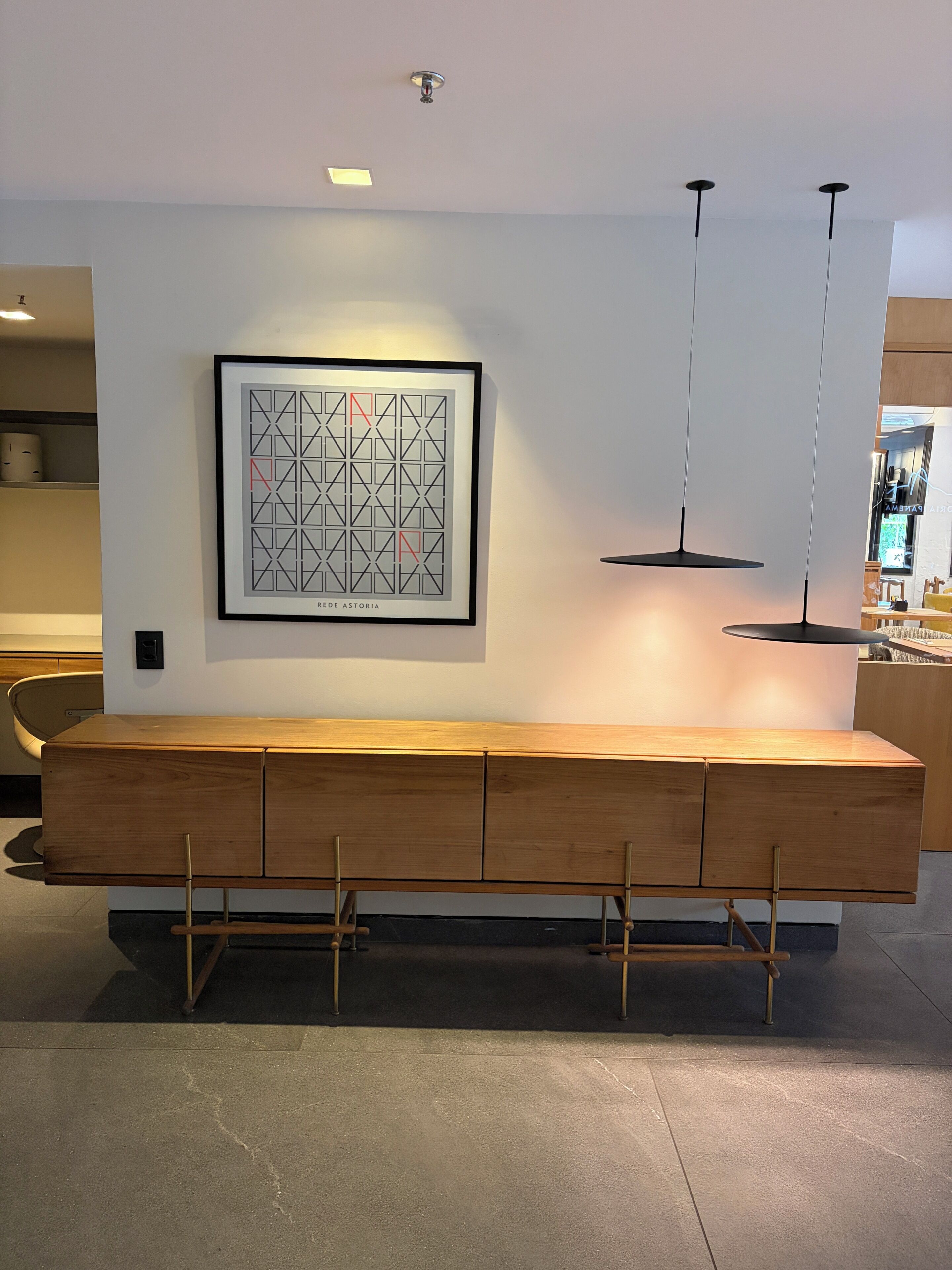 Eine moderne Küche mit einer Holzbank, Pendelleuchten und einem gerahmten Kunstwerk an der Wand.