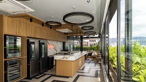 Una cocina moderna con electrodomésticos integrados, una encimera de madera y vistas a zonas verdes a través de amplios ventanales.