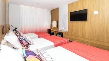 Una habitación de hotel con dos camas, un escritorio, un televisor y un espejo.