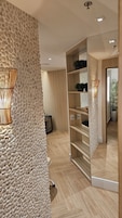 Um interior moderno com parede texturizada, piso de madeira, guarda-roupa espelhado e um vaso com planta.