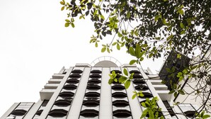 Un immeuble de grande hauteur, doté de nombreux balcons et d’une enseigne indiquant « La Résidence Jardins ».