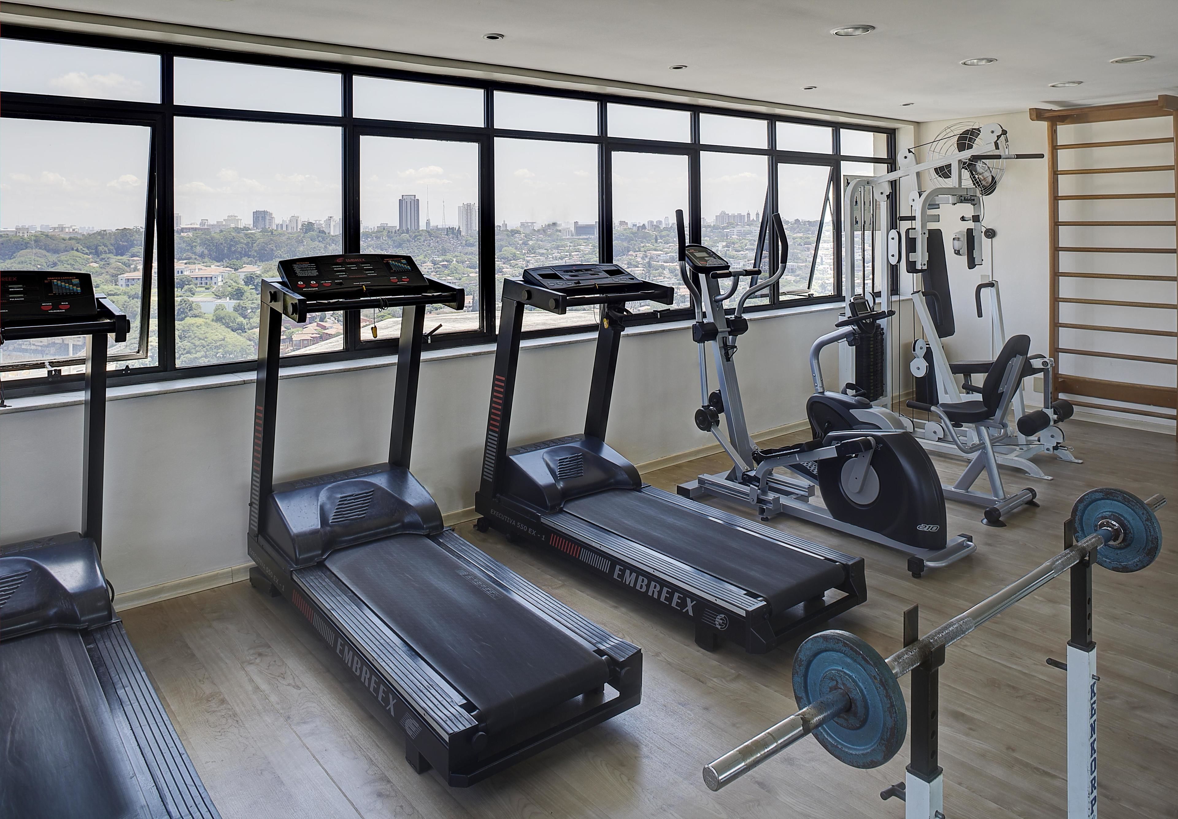 A gym with treadmills, an elliptical, and a weight bench.