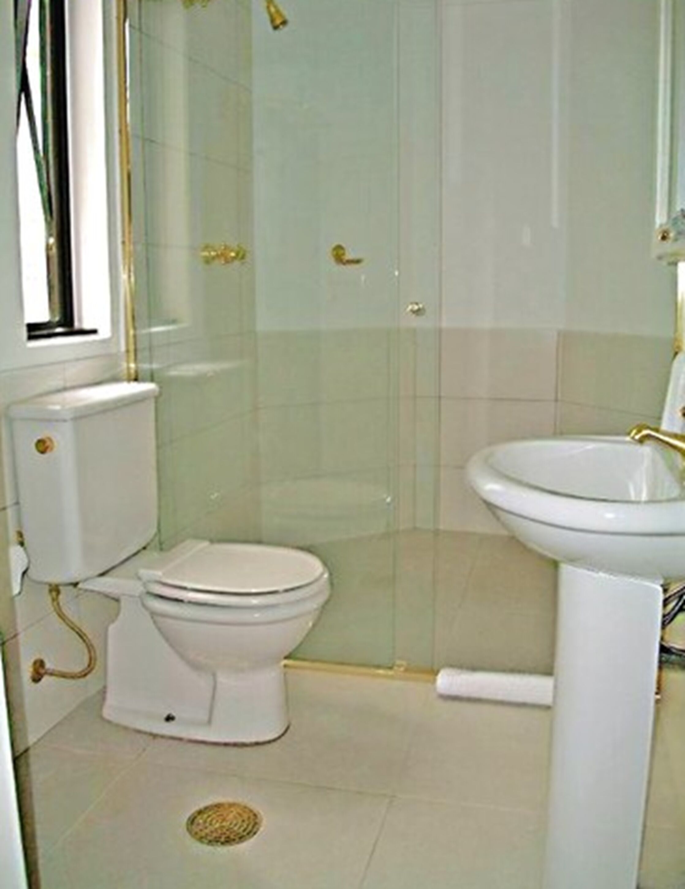 A bathroom with a toilet, a sink, and a shower enclosure.