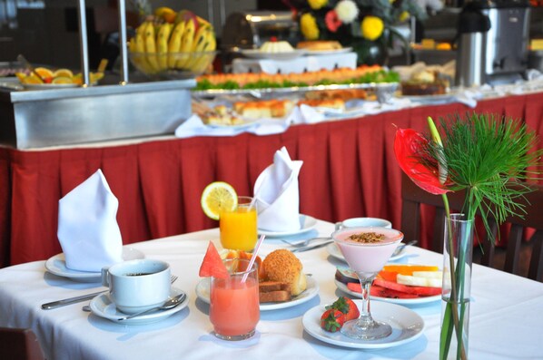 Un bufé de desayuno con diversas opciones de comida y bebidas.