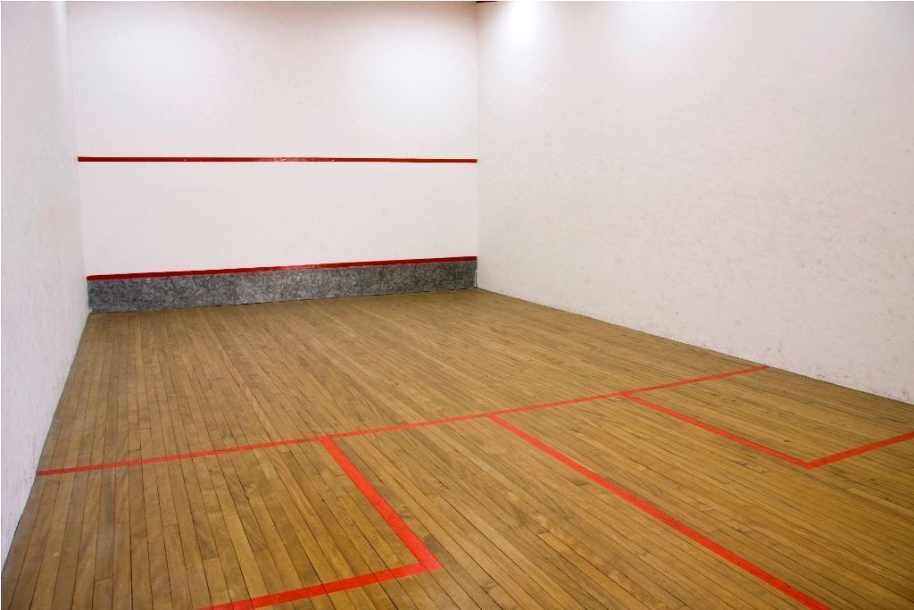 Ein Squashplatz mit Holzboden und roten Spiellinien.