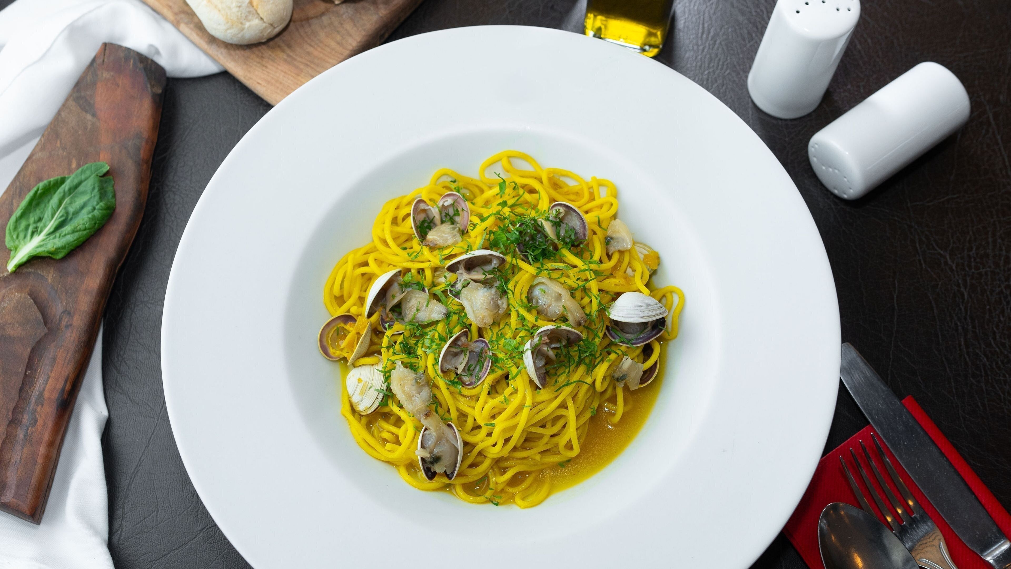 A plate of spaghetti with clams and herbs.