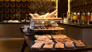 A buffet with various food items and a decorative wall with circular patterns. - InterContinental Santiago by IHG (Santiago)