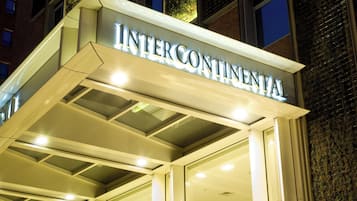 A hotel entrance with a sign reading 'INTERCONTINENTAL' and a modern design with glass railings and a metal structure.