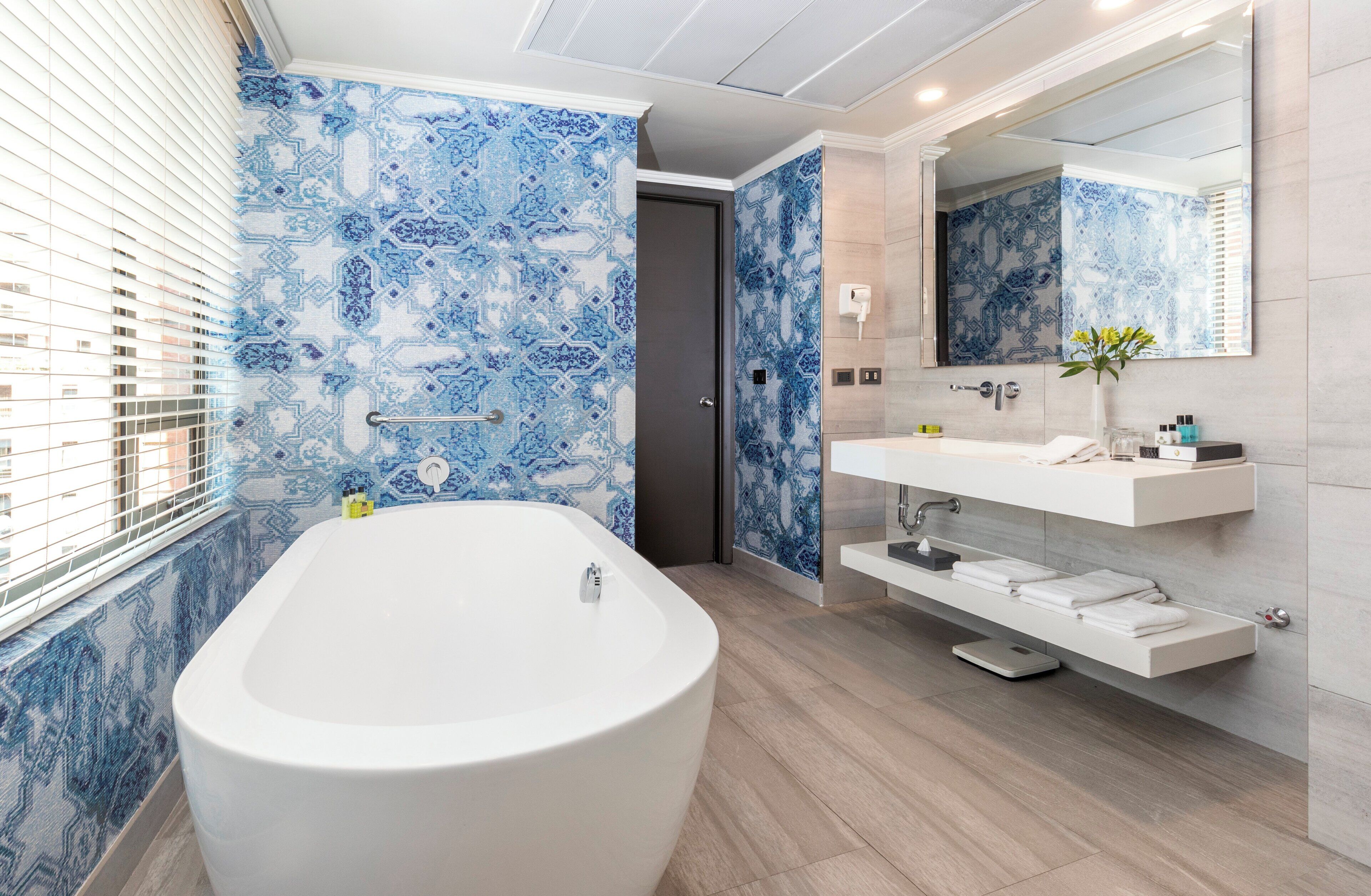 A modern bathroom with a freestanding bathtub, a vanity with a mirror, and a shower area.