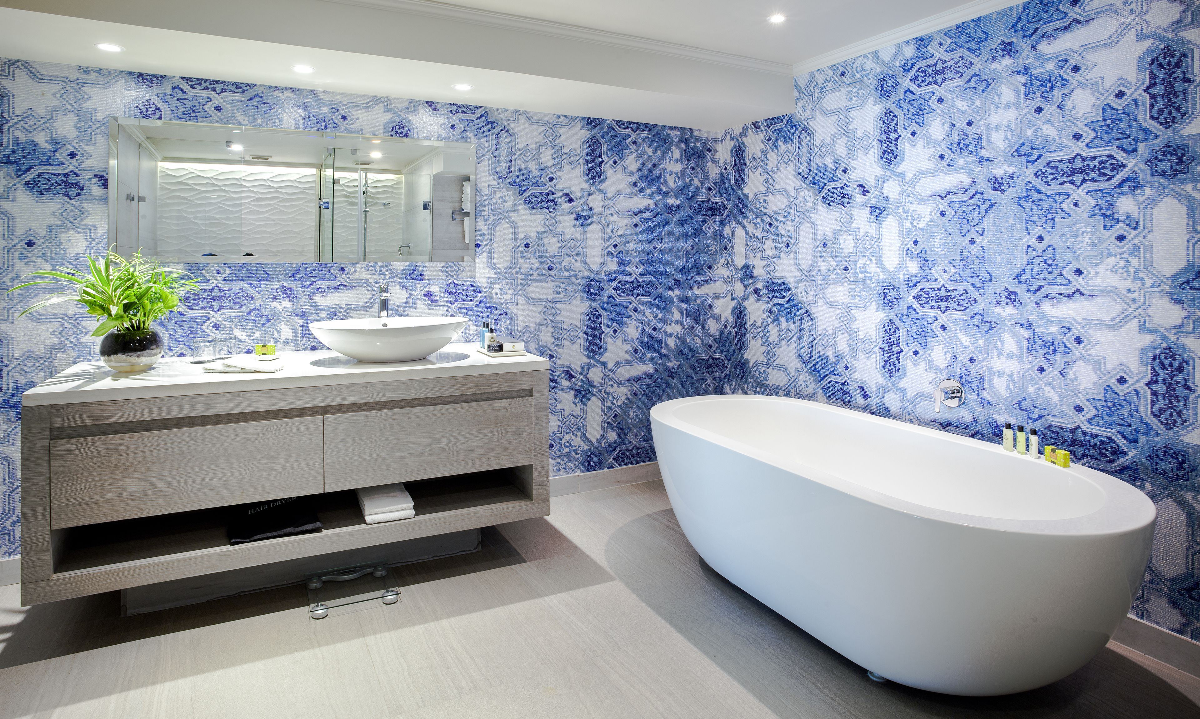 A modern bathroom with a freestanding bathtub, a vanity with a sink, and a large mirror.