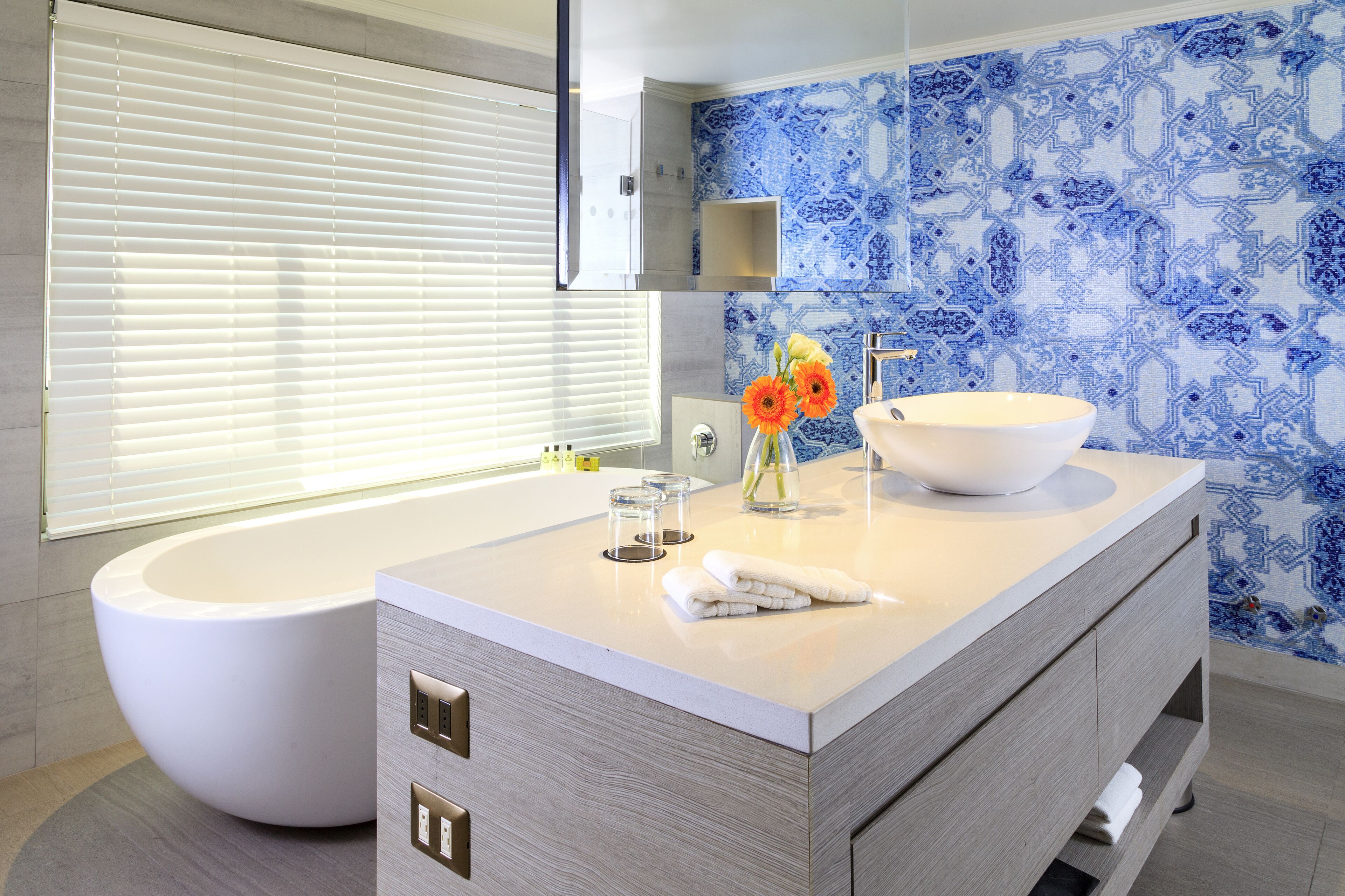 A modern bathroom with a freestanding bathtub, a large sink with a bowl, and a mirror above the sink.