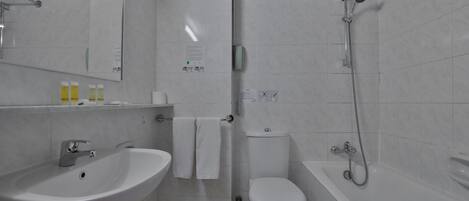 A modern bathroom with a sink, toilet, and bathtub.