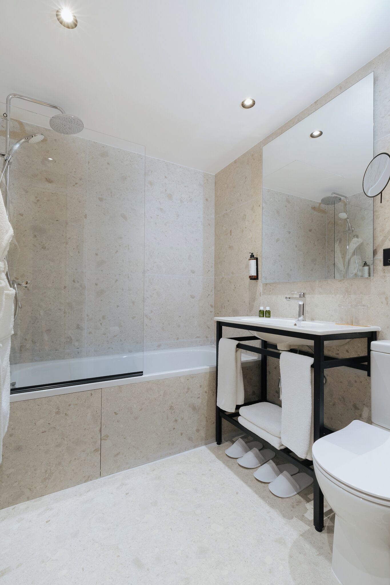 Un bagno moderno con doccia vetrata, lavandino bianco e uno specchio grande.