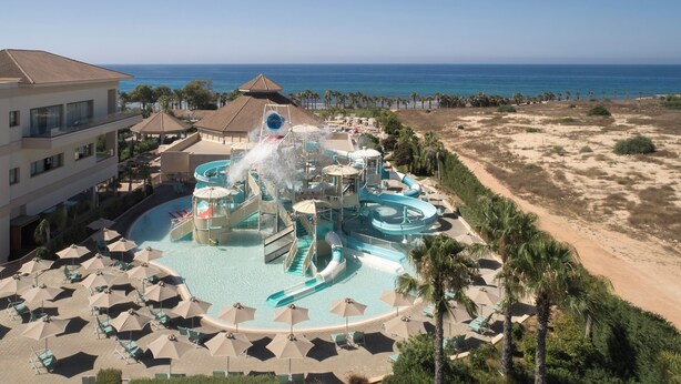 Een resort met een waterpark, strand en uitzicht op de oceaan.