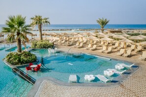 Een binnenzwembad, 2 buitenzwembaden en parasols bij het zwembad