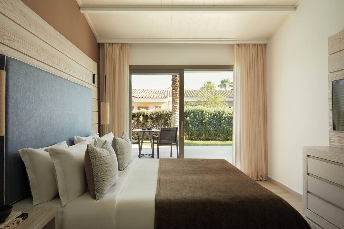 Een hotelkamer met een bed, een bureau en uitzicht op de omgeving.