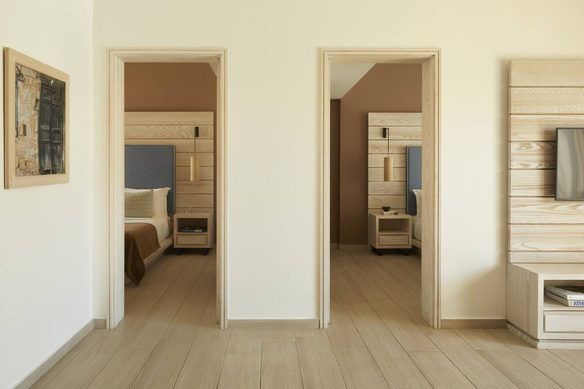 Een hotelkamer met een bed, nachtkastjes, een garderobe en een schilderij aan de muur.