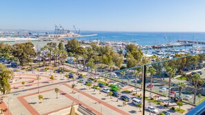 A marina with boats, a parking lot, and a view of the port in the background. - Sun Hall Hotel (Larnaca)