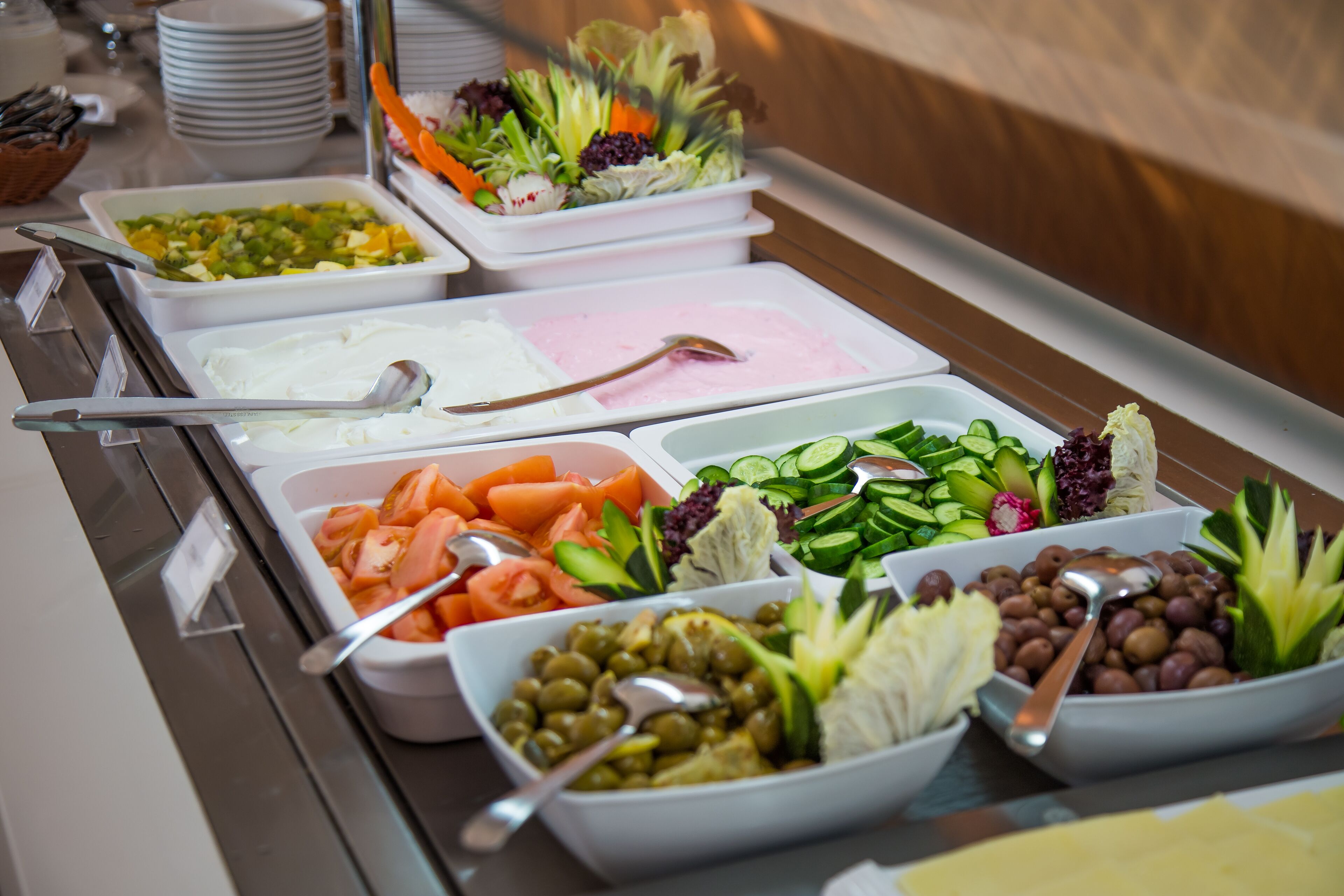Een buffet met diverse gerechten, waaronder groenten, fruit en dipsauzen.