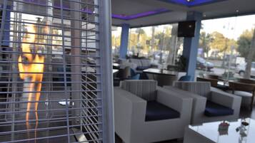 A modern lounge area with seating and a fire feature.