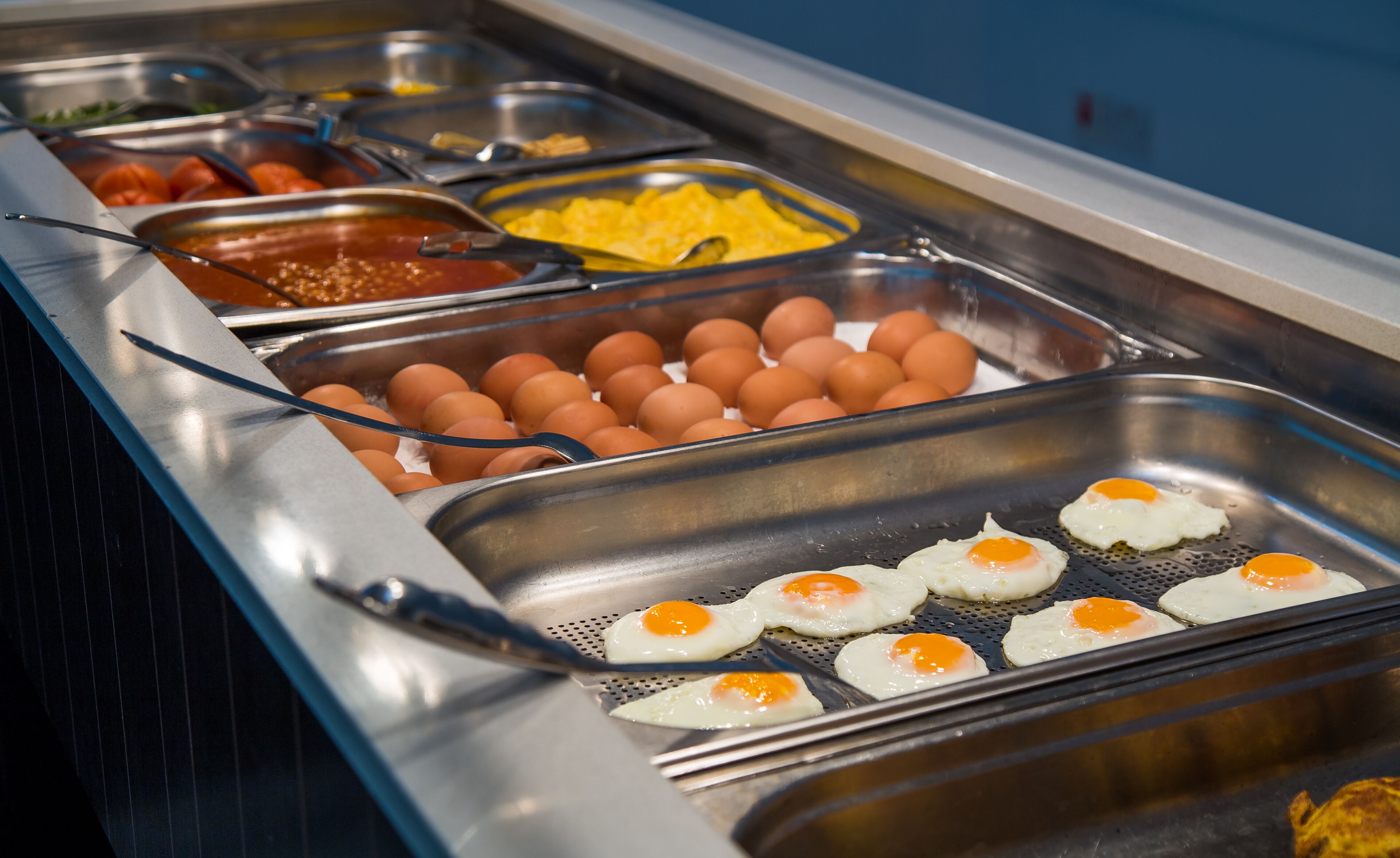A buffet with various food options including eggs, tomatoes, and other dishes.