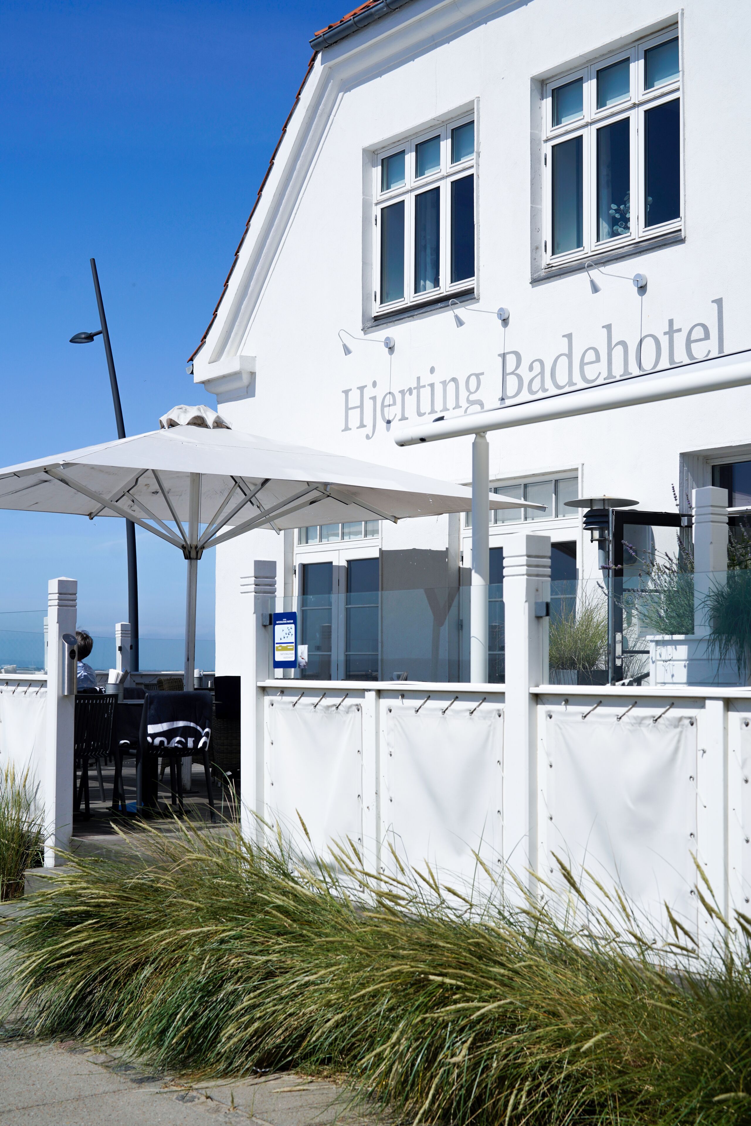 Ein weißes Gebäude mit dem Schriftzug "Hjerting Badehotel" auf der Fassade.