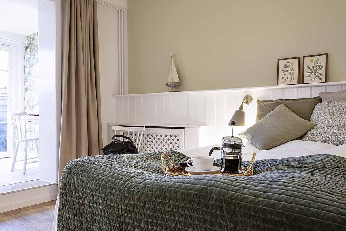 Une chambre d’hôtel équipée d’un lit, d’une table de chevet, d’une lampe, d’une machine à café et offrant une vue sur l’extérieur.