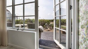 A room with a large sliding glass door leading to an outdoor patio area. - Hjerting Badehotel - Esbjerg (Esbjerg)